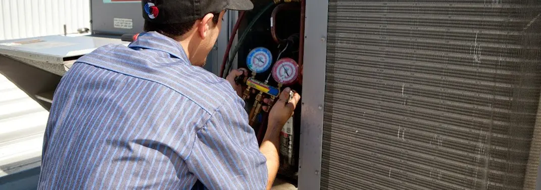 HVAC technician servicing a condenser unit in Boynton Beach